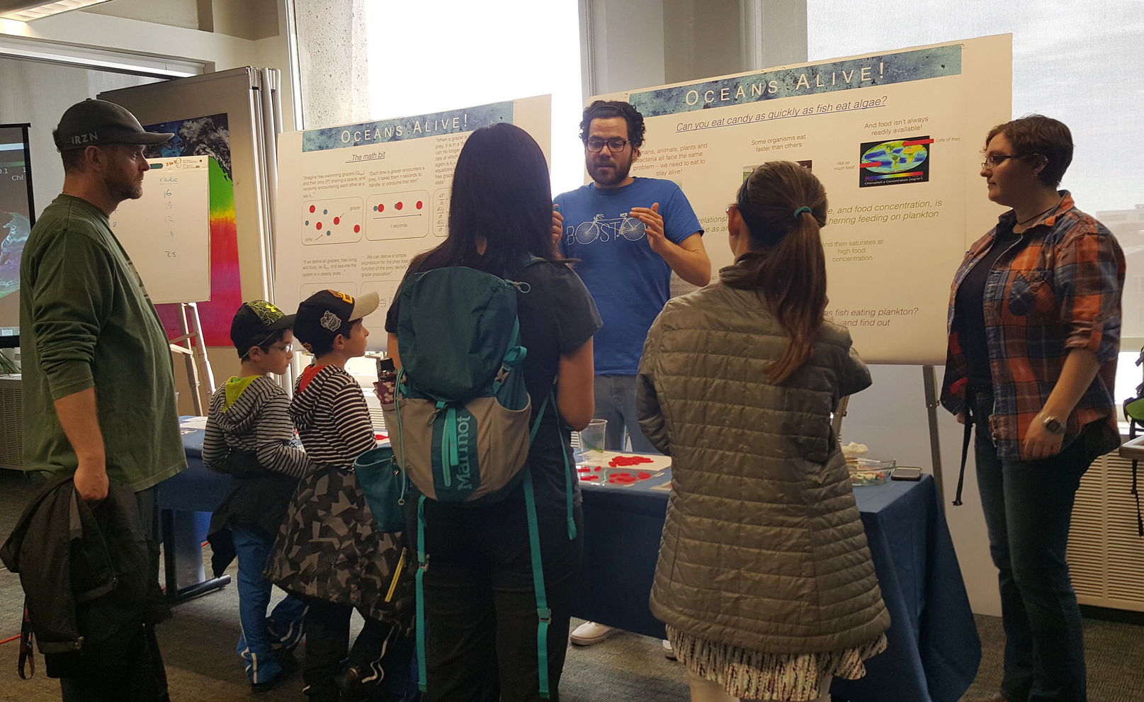 EAPS postdoc David Talmy helping guests understand math principles of some marine processes and illustrates them with a "fishing" game. (Image: Deepa Rao)