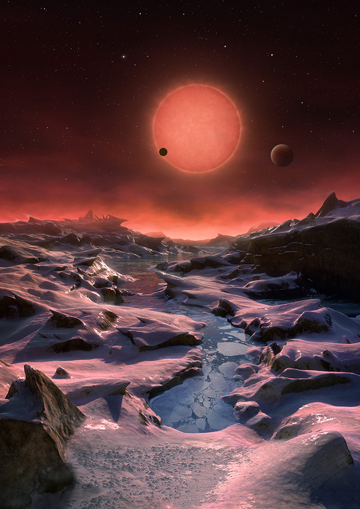 This artist’s impression shows an imagined view from the surface one of the three planets orbiting an ultracool dwarf star just 40 light-years from Earth that were discovered using the TRAPPIST telescope at ESO’s La Silla Observatory. These worlds have sizes and temperatures similar to those of Venus and Earth and are the best targets found so far for the search for life outside the Solar System. They are the first planets ever discovered around such a tiny and dim star. In this view one of the inner planets is seen in transit across the disc of its tiny and dim parent star. (Credit: ESO/M. Kornmesser)