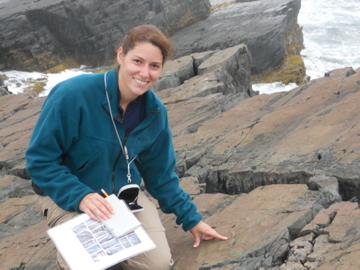 Dr. Kristen Miller in Newfoundland standing on a surface covered with ediacarn fossils